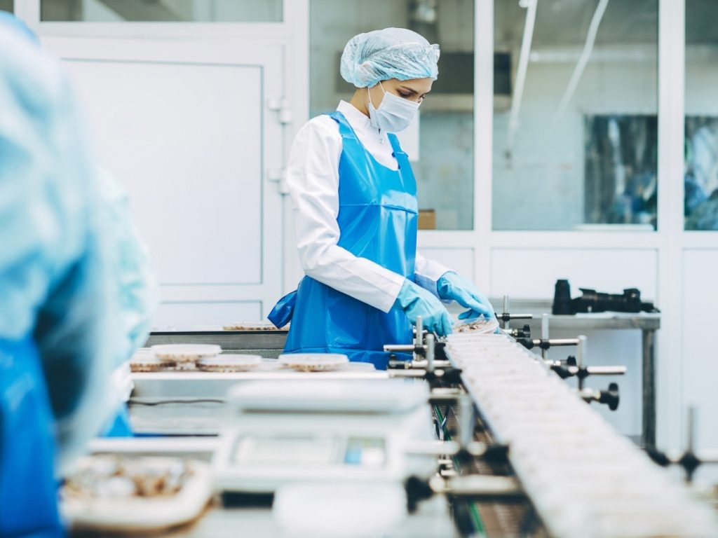 Hygienische Lebensmittelproduktion &ndash; Mitarbeiterin in steriler Arbeitsumgebung